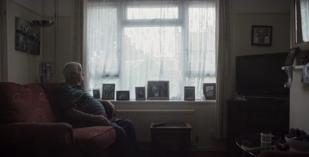 An elderly man looking towards the window